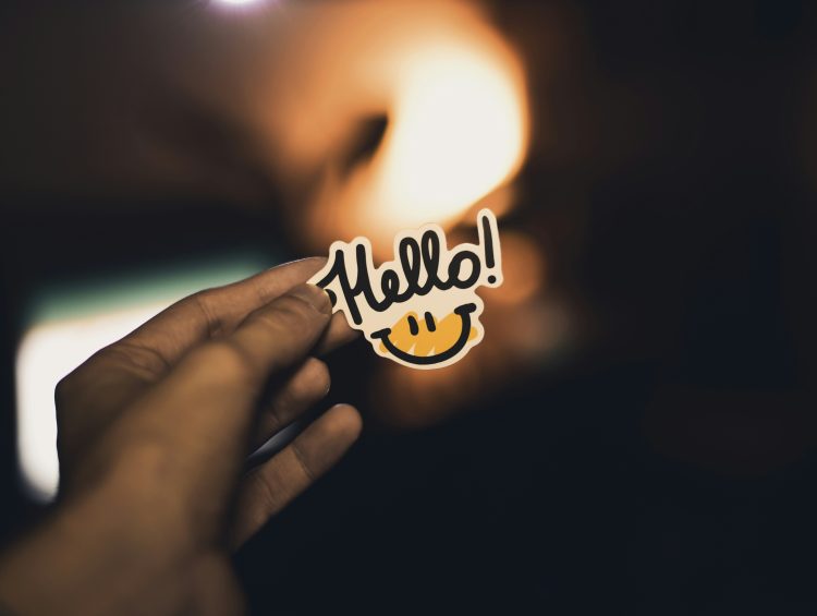 Ways To Use Stickers For Small Biz Marketing & Advertising* 1 a person holding up a sticker with the word hello on it