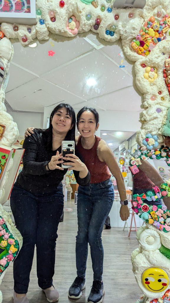 two women taking a picture of themselves in a mirror