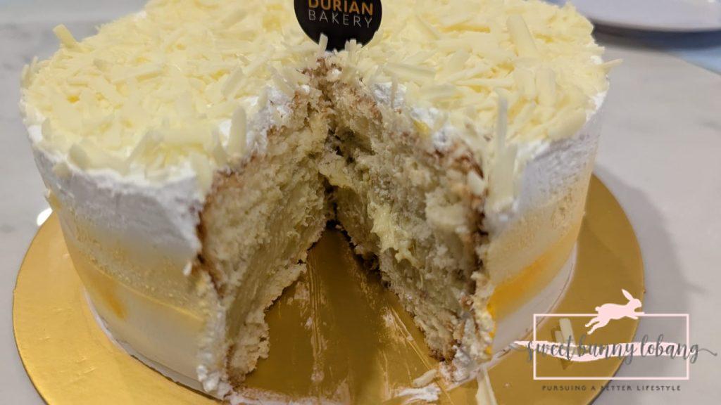 A classic Mao Shan Wang durian cake with a slice removed, showcasing its rich texture and creamy filling.
