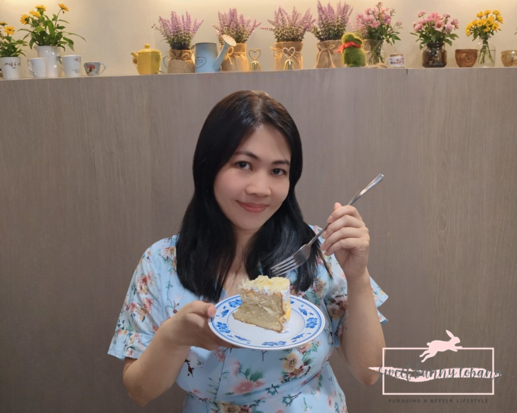 A woman holds a plate featuring a slice of Classic Mao Shan Wang Durian Cake, showcasing its rich texture and flavor.