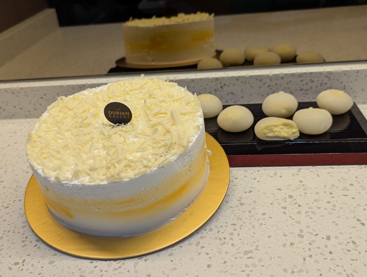 A beautifully frosted white cake from The Durian Bakery, featuring a pristine white exterior.