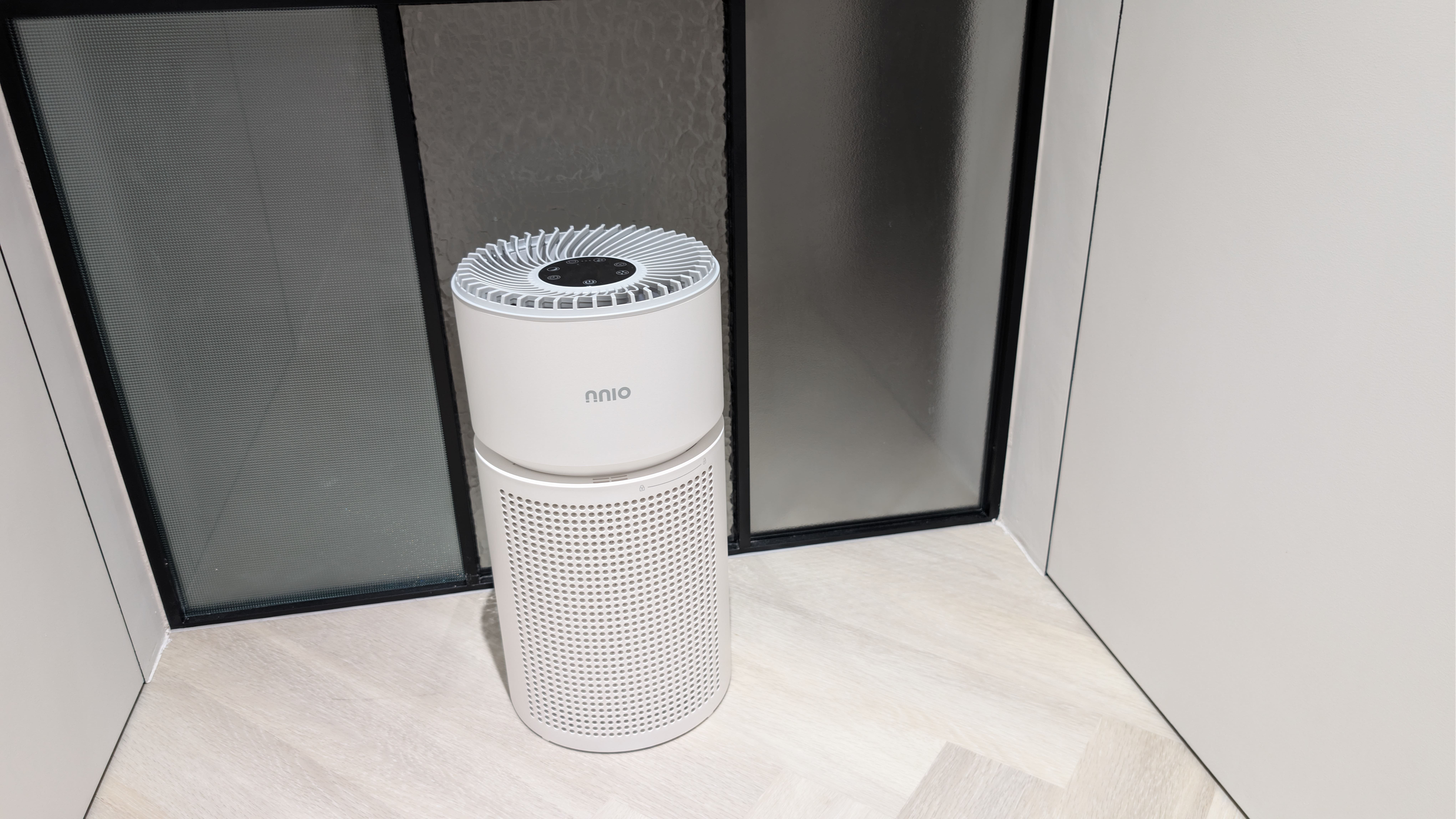 White HEPA-14 air purifier on a wooden floor, designed for efficient air filtration in indoor spaces.